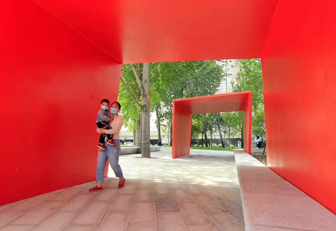 橘红色的廊架为游人遮阳.