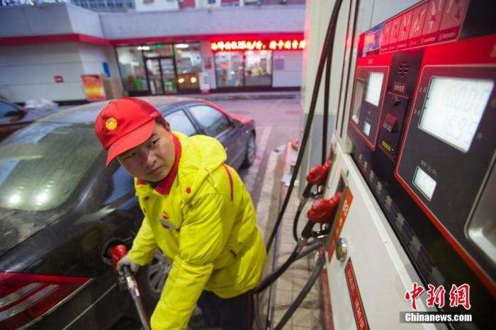 资料图:加油站工作人员为汽车加油. 张云 摄