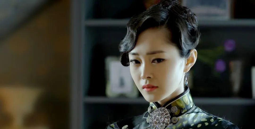 于曼丽站在房间中央,手拿一方湘绣手绢,用缠绵婉转的