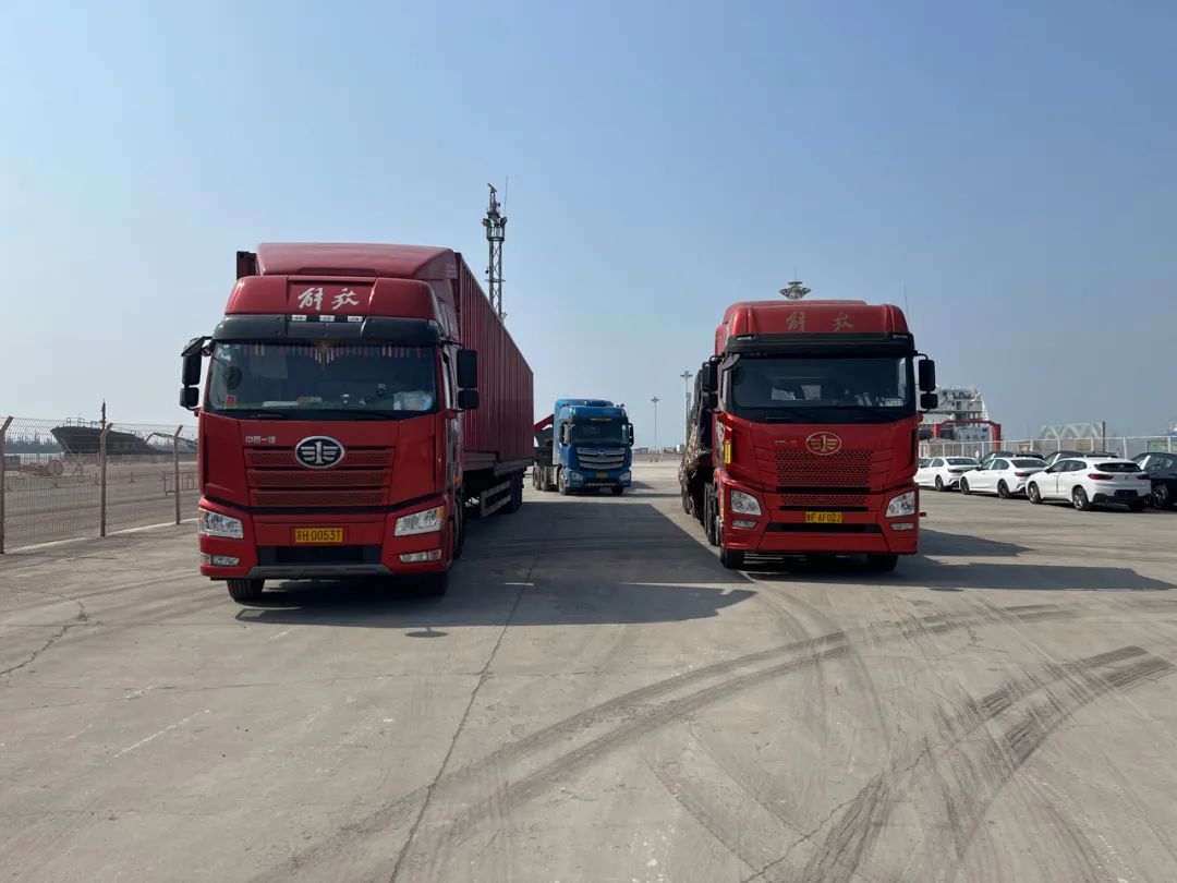 4月20日，大连湾新港，被扣下的几辆卡车。三小时后，警车“开道”送上高速。新京报记者 杜寒三 摄