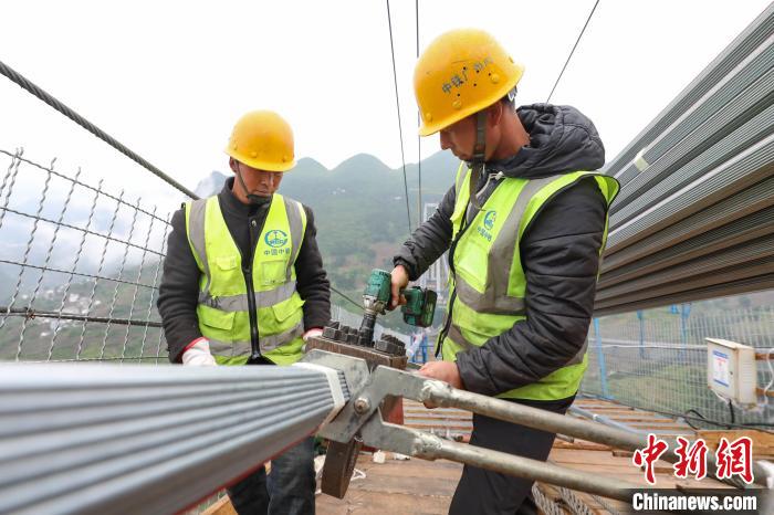 两位工人在大桥猫道上安装握索器. 瞿宏伦 摄