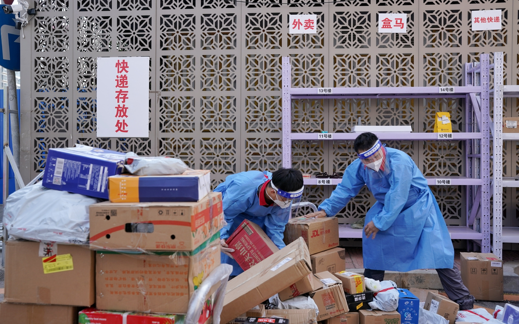 快递员在小区外设立的快递存放处分拣快递.新京报记者 裴剑飞 摄
