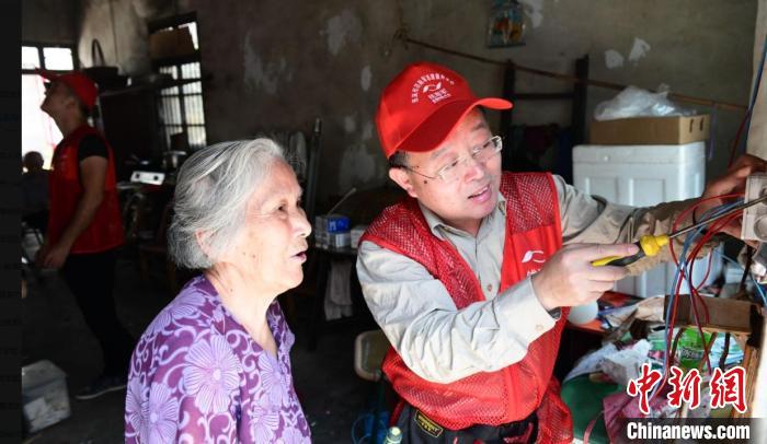 钱海军在慈溪为当地低保户和行动不便的老人免费改造照明线路。　国家电网浙江慈溪市供电公司 供图