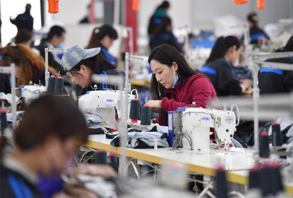 工人在延安市延川县华延服装公司车间内工作(3月31日摄).