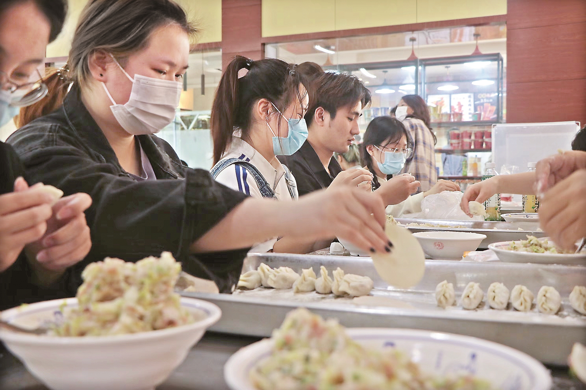 南理工泰州科技学院的大学生们学包饺子.
