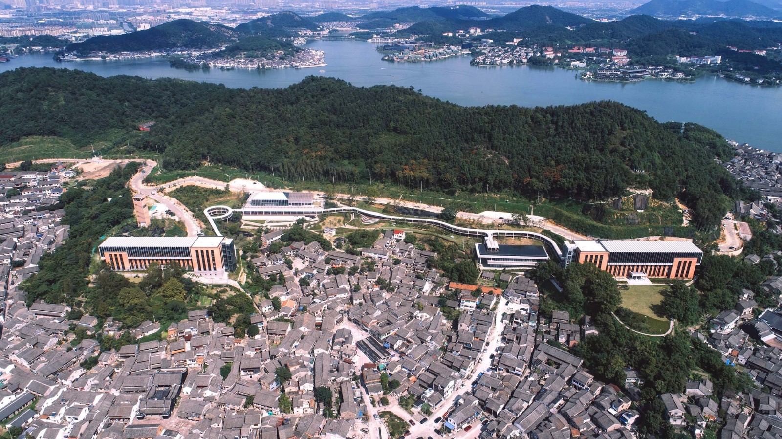 带状展开,两端东西主楼,中部访客中心和陶公讲堂,四栋建筑通过景观