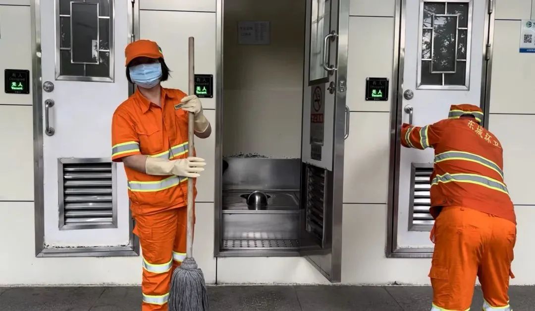 保洁员对公厕进行清扫消毒/记者拍摄