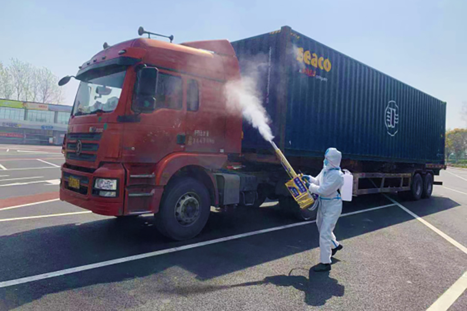 4月8日，职责人员在成子湖奇迹区对上海港集卡车辆进行消毒。 江苏交通控股有限公司 供图