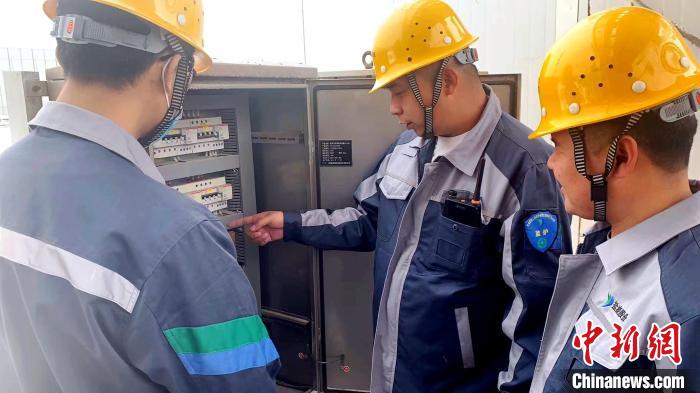 图为徐铭泽和工友交流研究。　盐湖集团供图