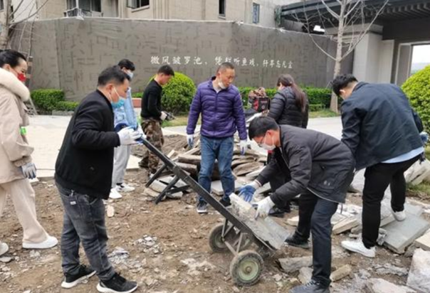 ▲因施工进展慢，河南一小区业主自发到工地搬砖，图片来自中国新闻周刊。