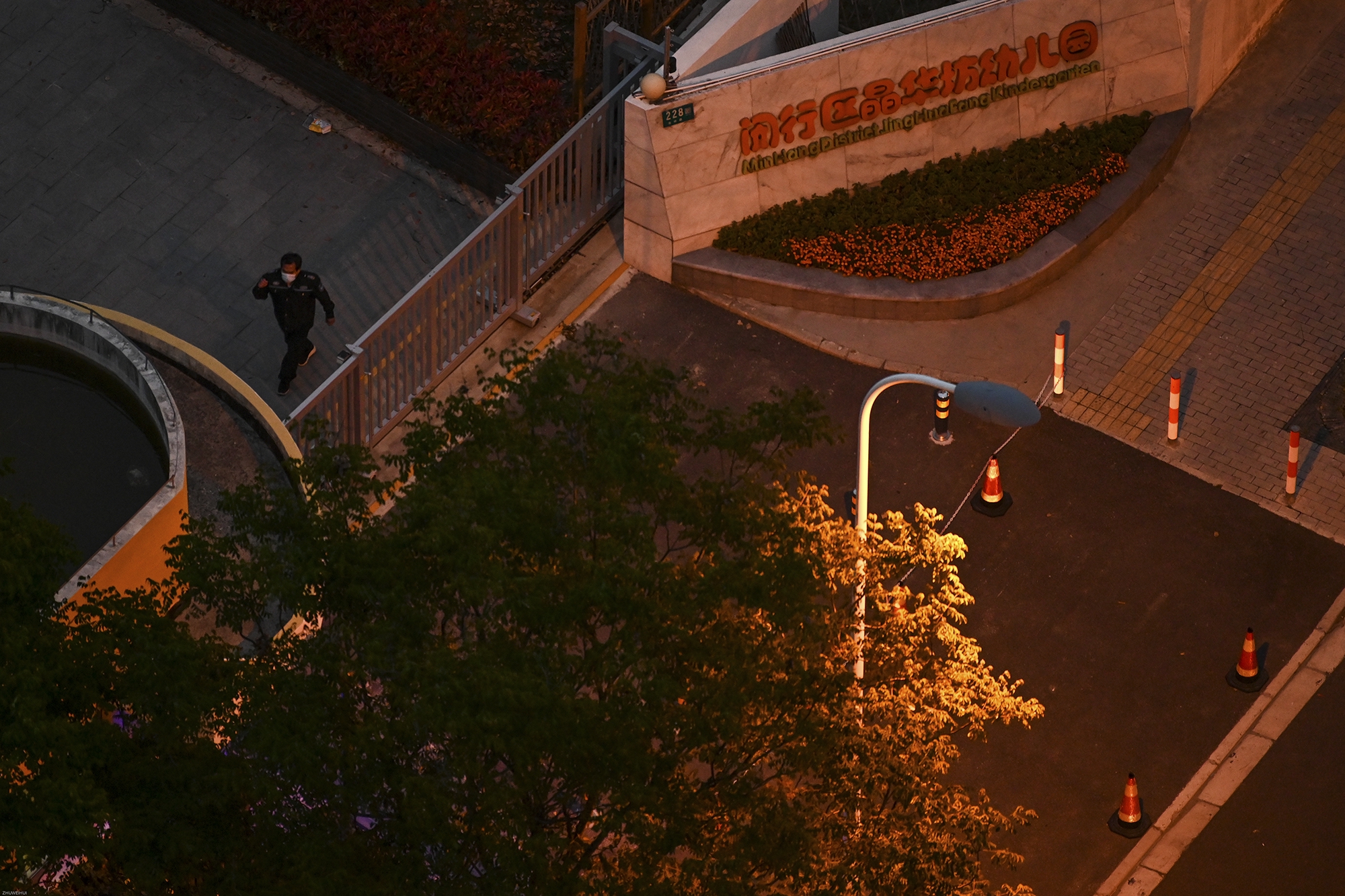 2022年4月15日,上海晶华坊,楼下马路对面的幼儿园,值守的保安把手机