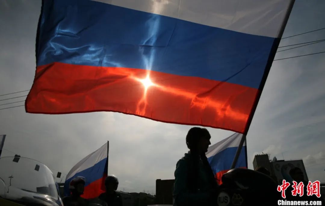 资料图：俄罗斯国旗日，民众举旗庆祝。