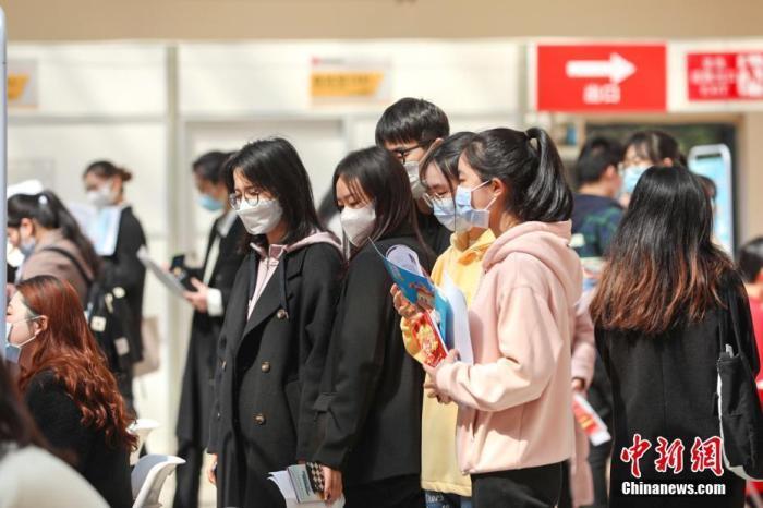 资料图:3月8日,位于江西南昌的江西财经大学蛟桥园校区,几位大学生在排队等待面试。刘力鑫 摄