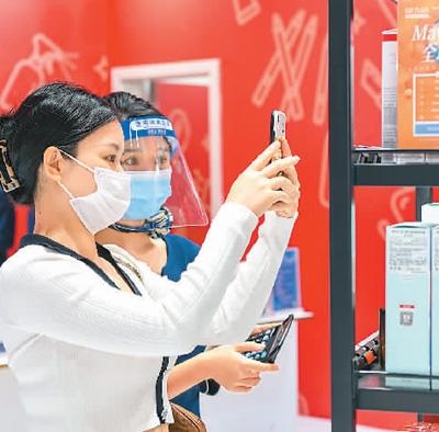 今年“五一”假期期间,海南5家免税经营主体旗下的10家离岛免税店推出发放消费券等多项促消费举措。图为在海南省海口市海控全球精品免税城内,顾客在选购免税商品。 苏弼坤摄(人民图片)
