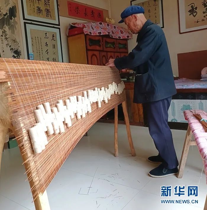 刘智慧正在编织制作麻纸的竹帘。（受访者供图）