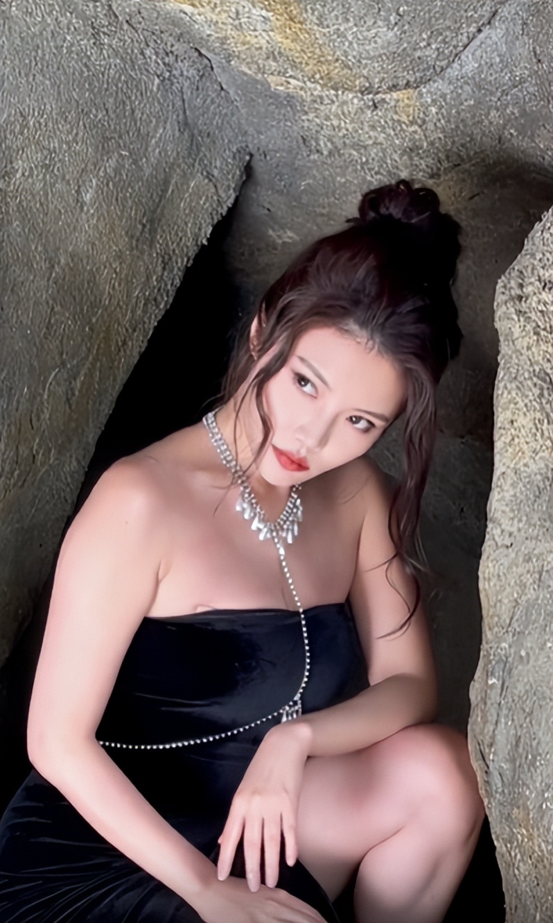 徐冬冬在山洞拍性感照穿抹胸黑裙身材丰腴蹲地上大腿肌肉明显