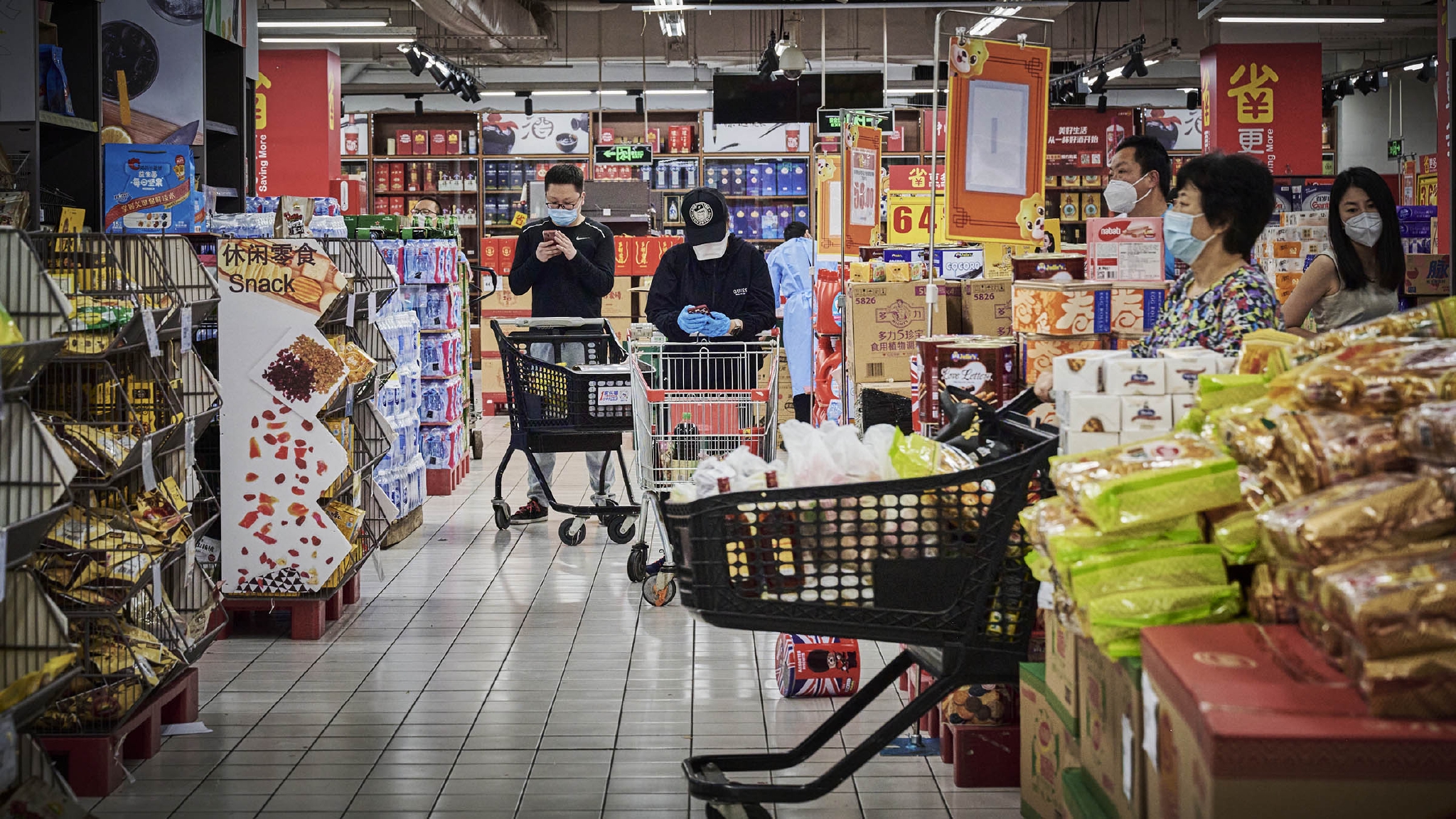 2022年5月17日,上海家乐福宜山店,推着装满商品的购物车的市民.