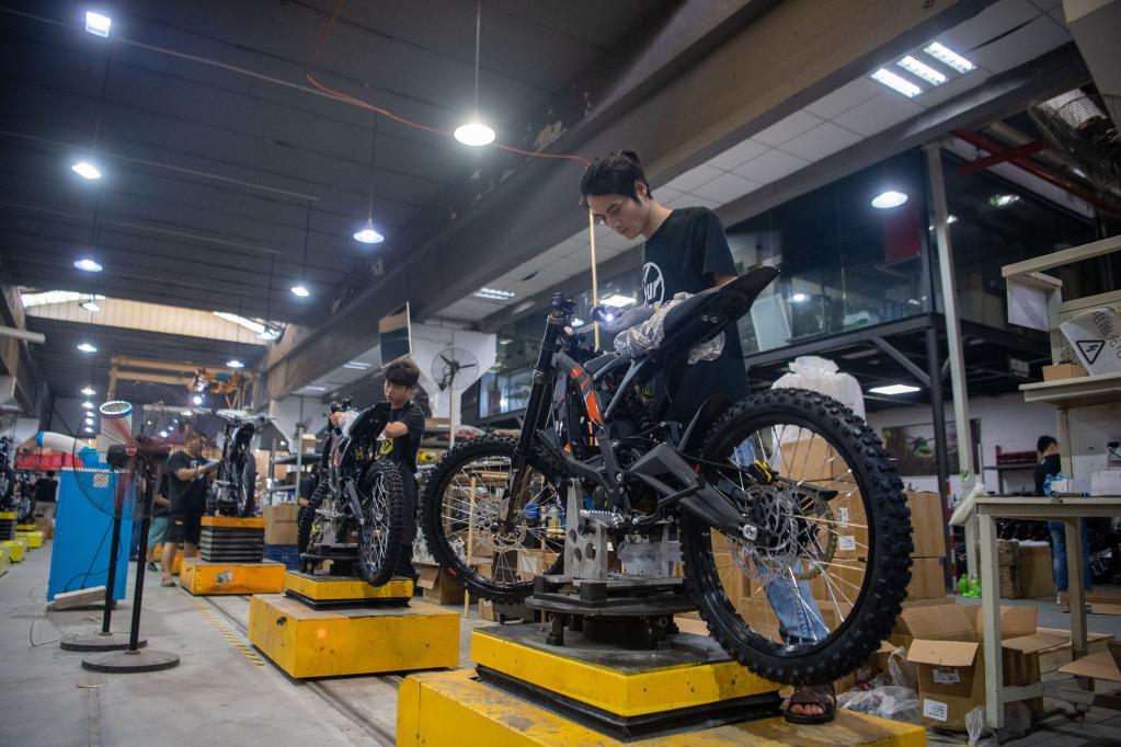 4月24日,在重庆虬龙科技有限公司,工人在生产车间内组装摩托车.