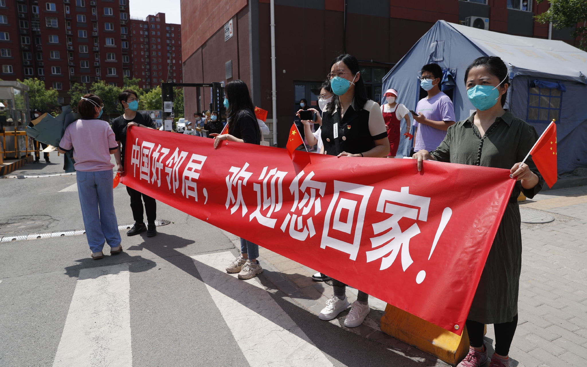 冠华苑小区外,居民拉着横幅,欢迎"中国好邻居"回家.