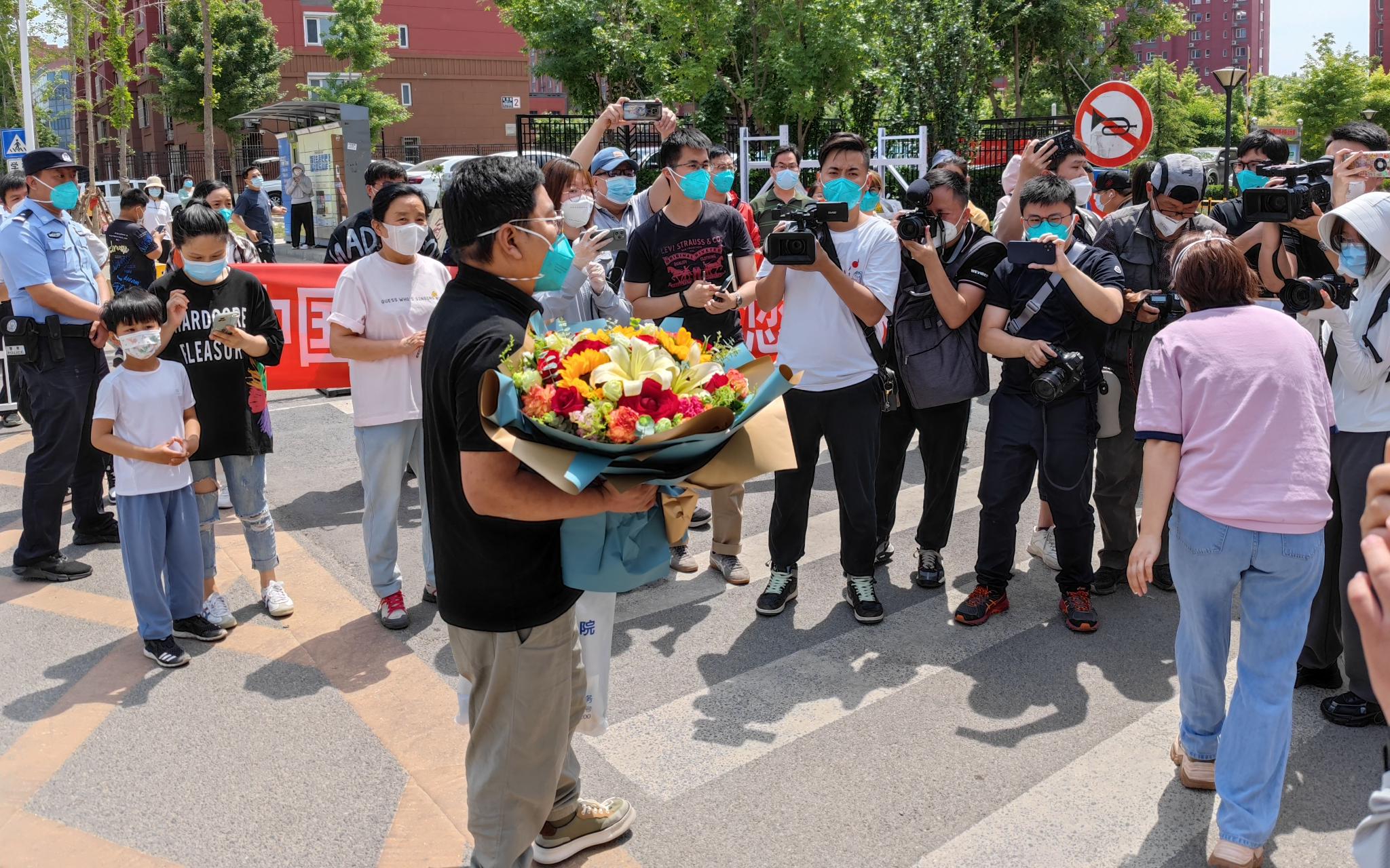 5月18日上午11点，在冠华苑社区门口，邻居们欢迎张旭回家。新京报记者 王巍 摄