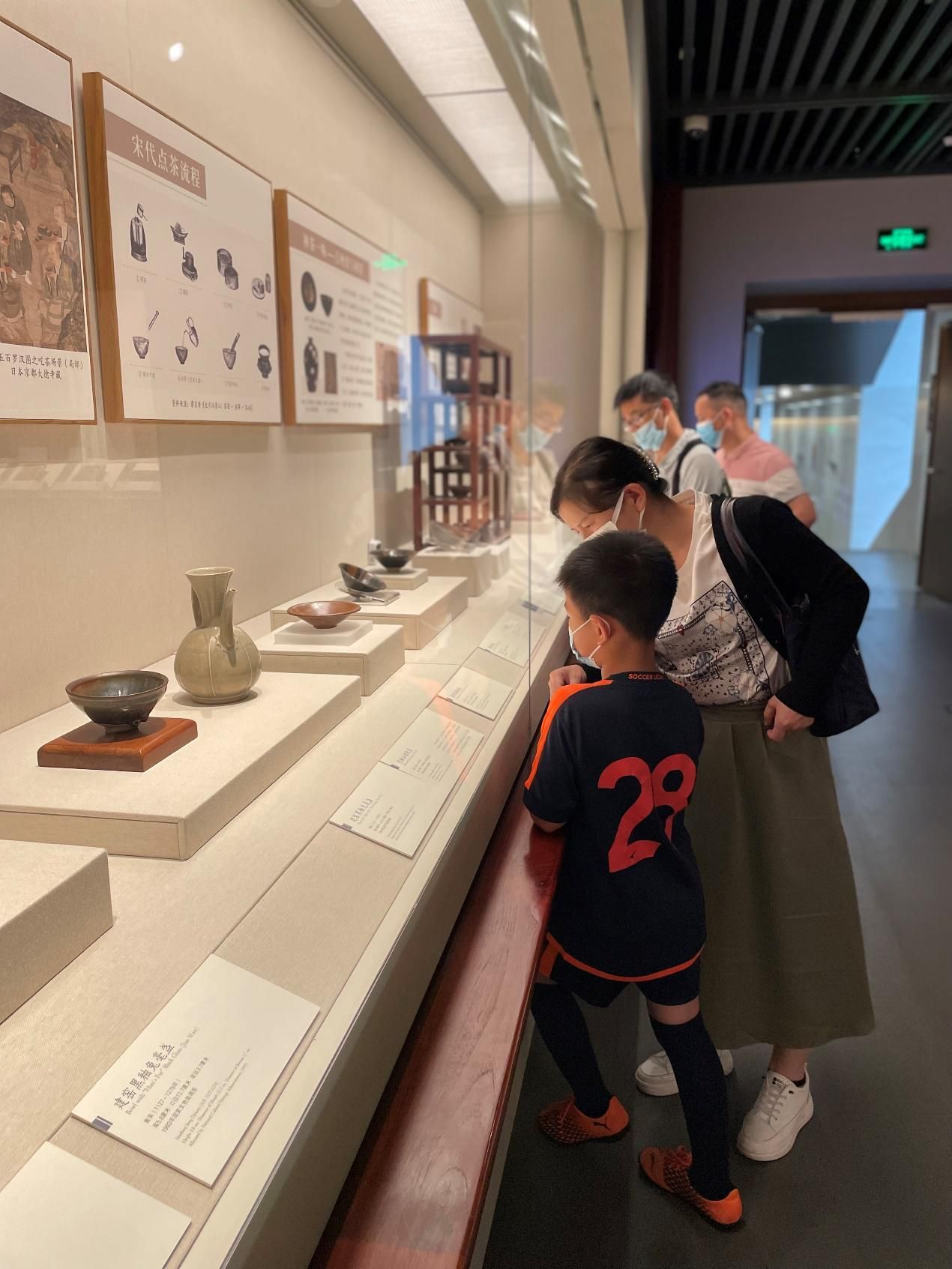 5月15日,深圳博物馆古代艺术馆展厅内,一名参观者向孩子讲解展品.