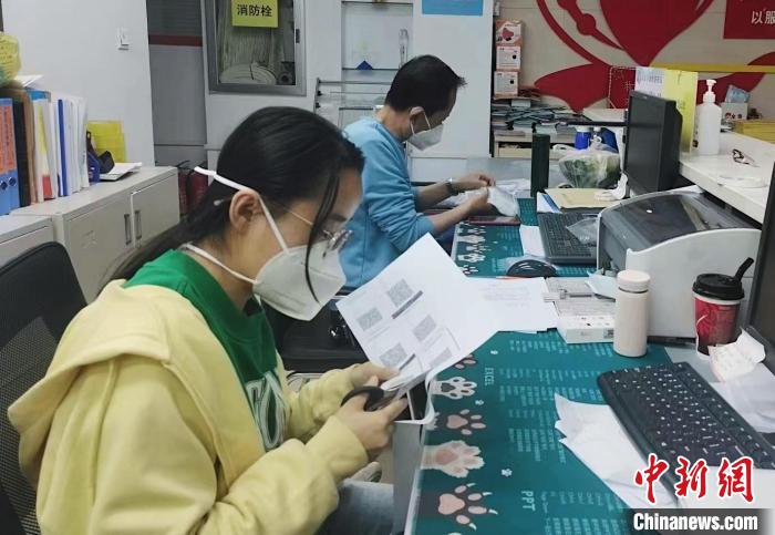 图为工作人员正在为老人制作便携式核酸检测采集码卡片。　受访者供图