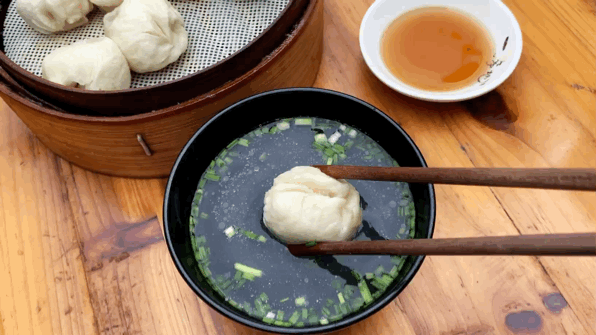 △把汤包在葱叶骨头汤里快速浸一下，清香鲜美。