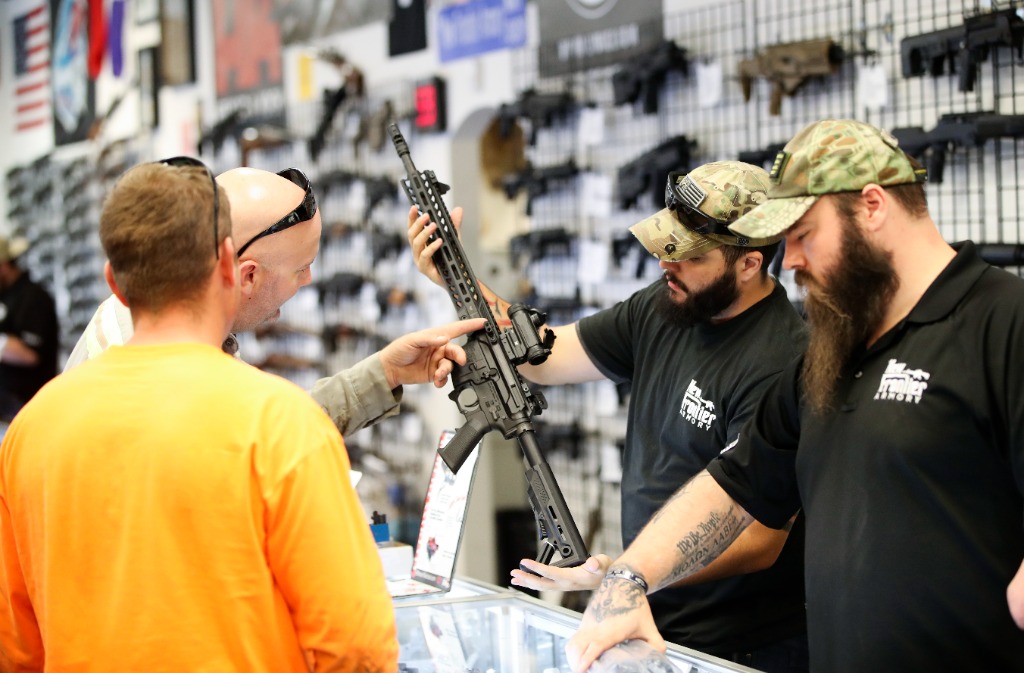 　　2017年10月4日，在美国拉斯维加斯的“新前线”枪械商店，店员为顾客展示枪支。新华社记者 王迎 摄