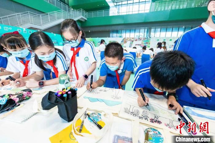 图为深圳坪地兰陵学校学生现场进行环保袋手绘创作。　主办方 供图