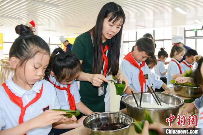重庆广福未来学校的小学生们在老师的指导下包粽子. 何蓬磊 摄