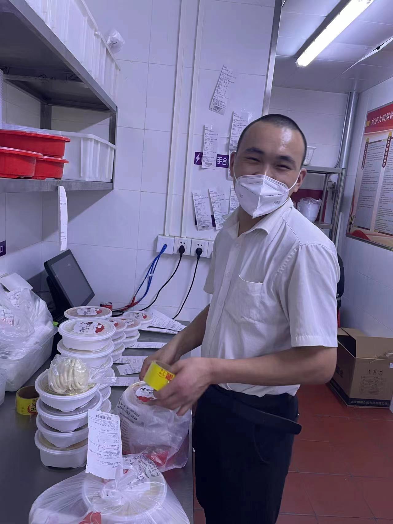张志龙在餐厅后厨帮忙打包外卖.受访者供图