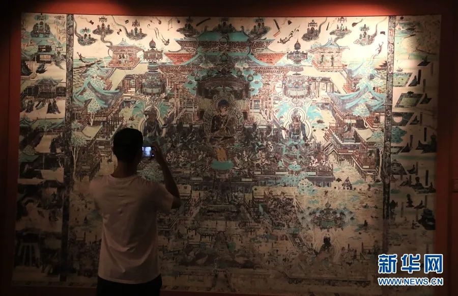 5月30日，游客在莫高窟观看《千年营造——敦煌壁画中的建筑之美》特展。新华网发 （张晓亮 摄）