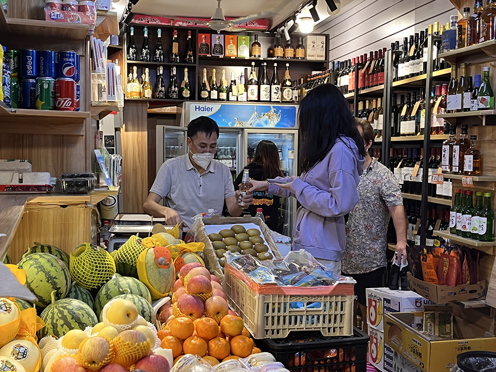 6月1日0点20分左右,上海长乐路上一家烟酒水果店,老板为一位顾客开啤酒。澎湃新闻记者 邹佳雯 图