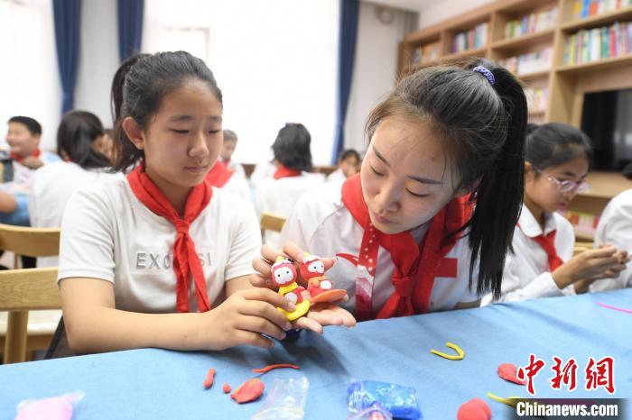 圖為張夢秋與小學生們一起做手工. 高雷 攝