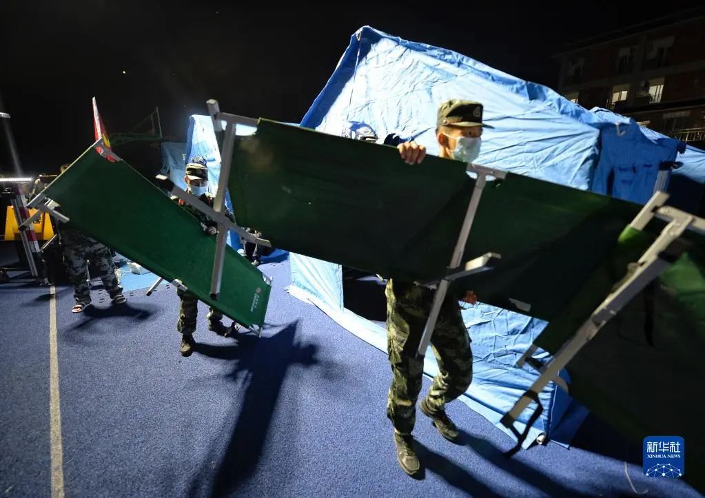 6月1日，在四川雅安市芦山县太平镇太平中学安置点内，武警雅安支队官兵在搬运床。新华社记者 刘坤 摄