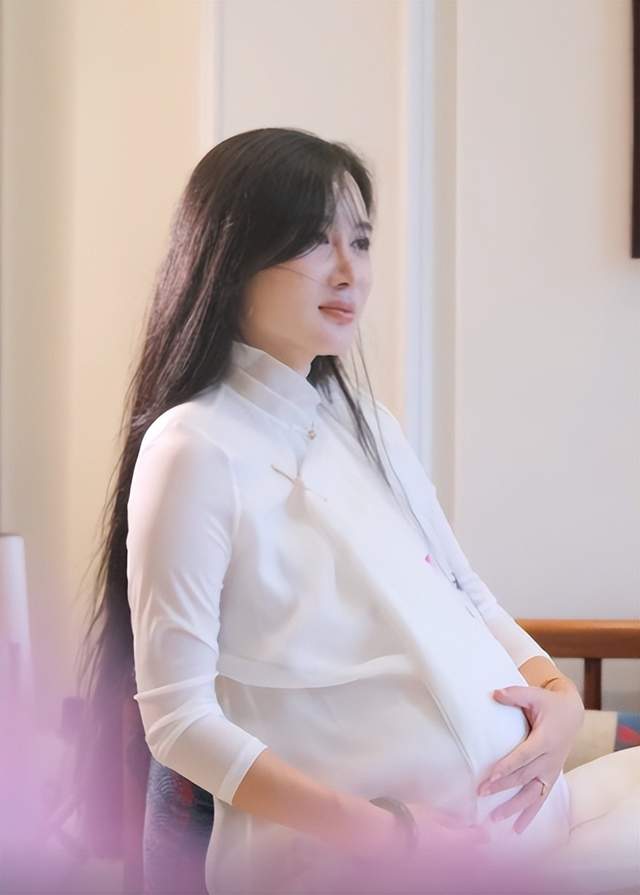 图片中杜星霖挺着大肚子手抚在小腹处,眼中充满温柔慈爱,仿佛滴出水来