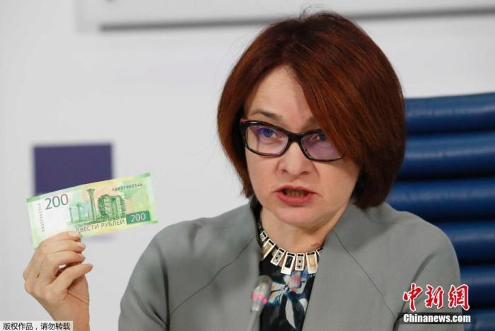 资料图：俄央行行长纳比乌娜手拿200卢布钞票。