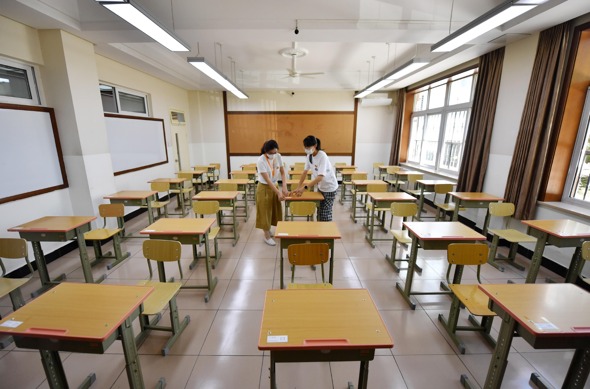 考场内,每个桌子右上角都贴好了写有考生姓名和准考证号的桌贴.