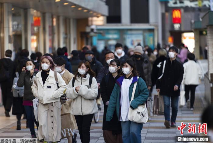 资料图:日本东京街头戴着口罩的人们.
