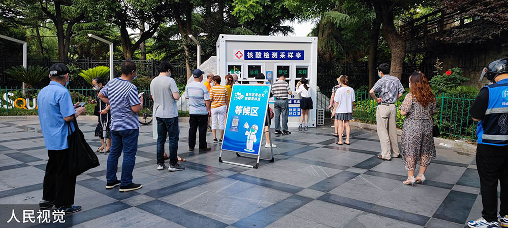 2022年6月4日,上海,街头的核酸采样工作站前,市民排队做核酸.