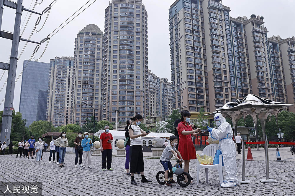 在上海市黄金城道步行街长宁核酸采样工作站,市民排队进行核酸采样