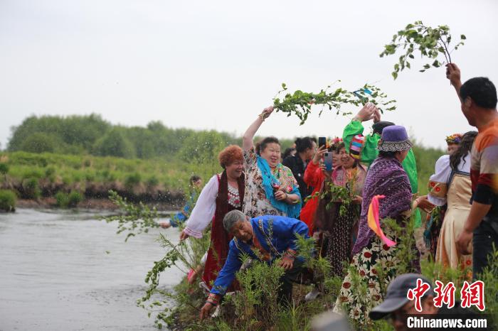 图为族里的长者用树枝蘸着河水洒在人们身上. 张宏 摄