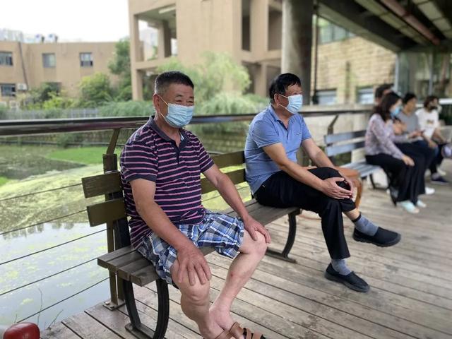 居民们坐在北仑区东海明园小区河岸休闲区乘凉