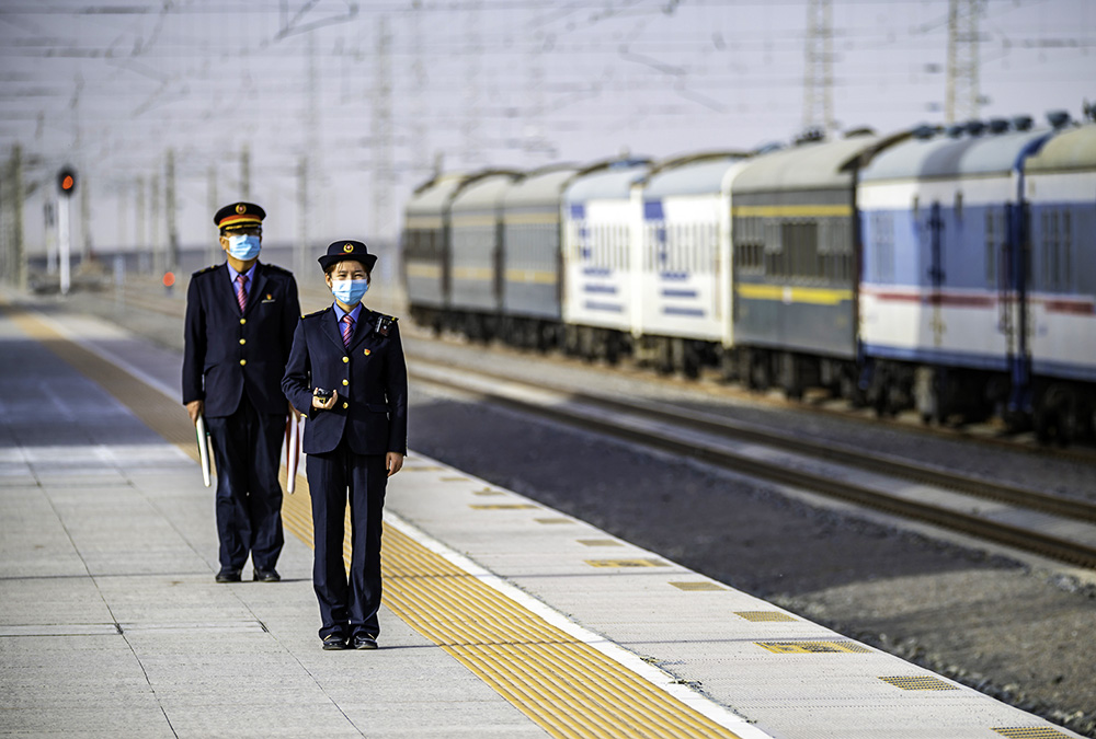 巴音郭楞蒙古自治州格库铁路尉犁站,客运值班员正在火车站台接发列车