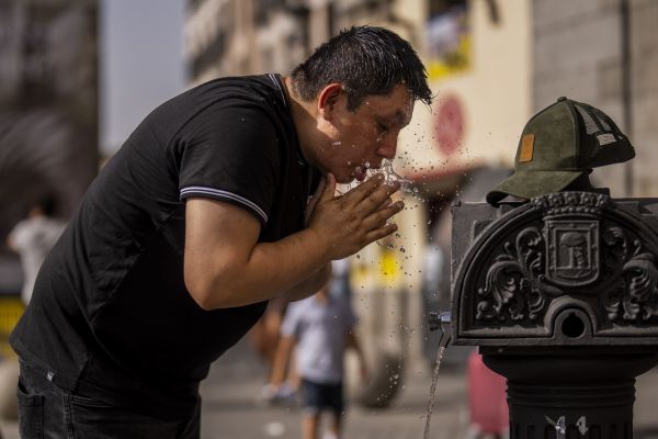 18日，一名男子在马德里街头接水消暑。（美联社）