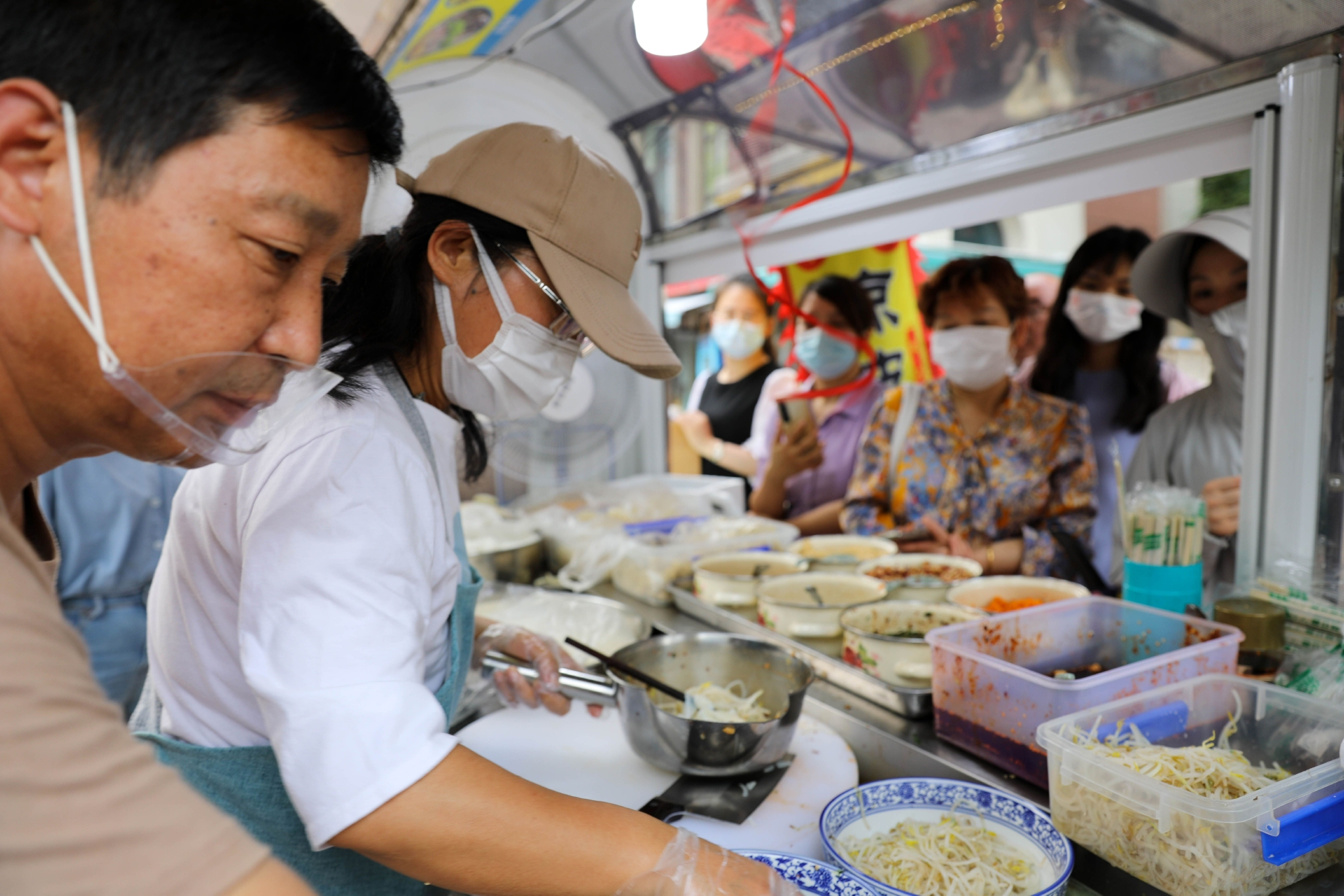 新华社记者 曹力 摄6月13日,朱艳在凉皮摊忙碌着.新华社记者 王菲 摄