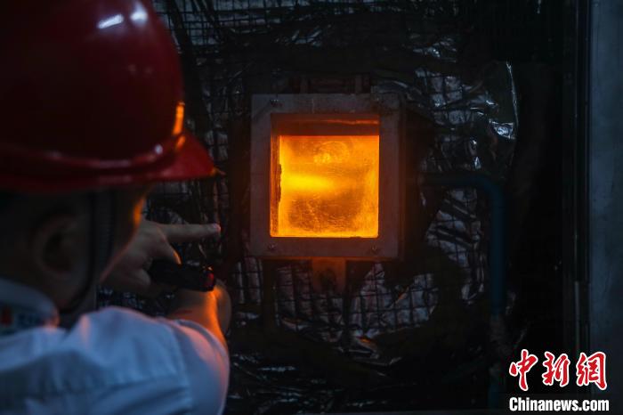 图为垃圾仓内的"大爪子"将垃圾投放进焚烧炉. 刘力鑫 摄