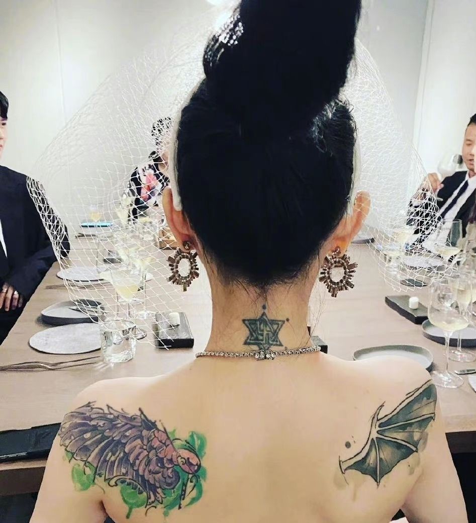 45岁的大s,背对镜头,头发乌黑,高高束起,脖颈和肩膀两侧的纹身透露她