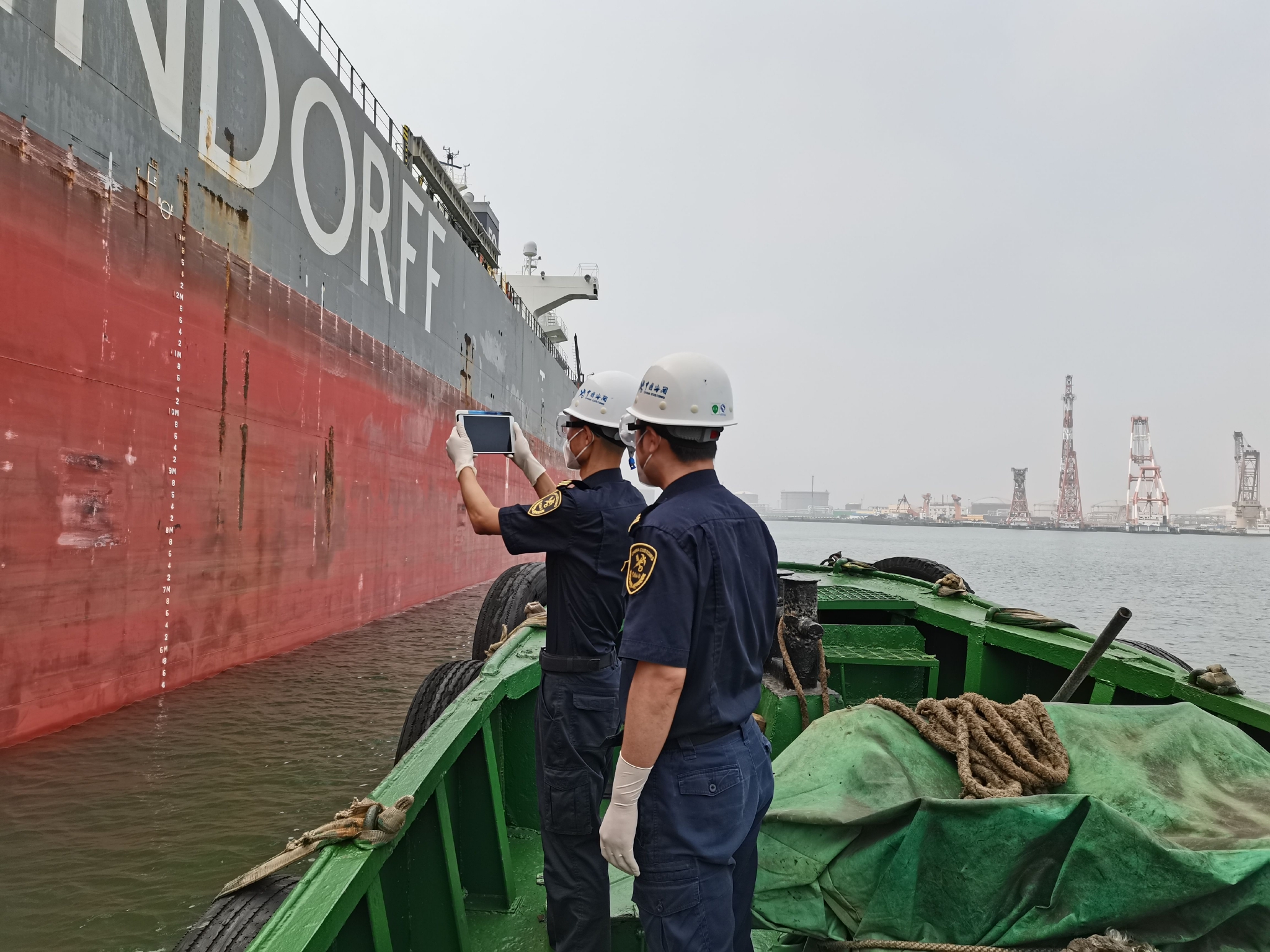 做好查验准备,他们用手中的查验平板电脑对船舶六面水尺标记进行拍摄