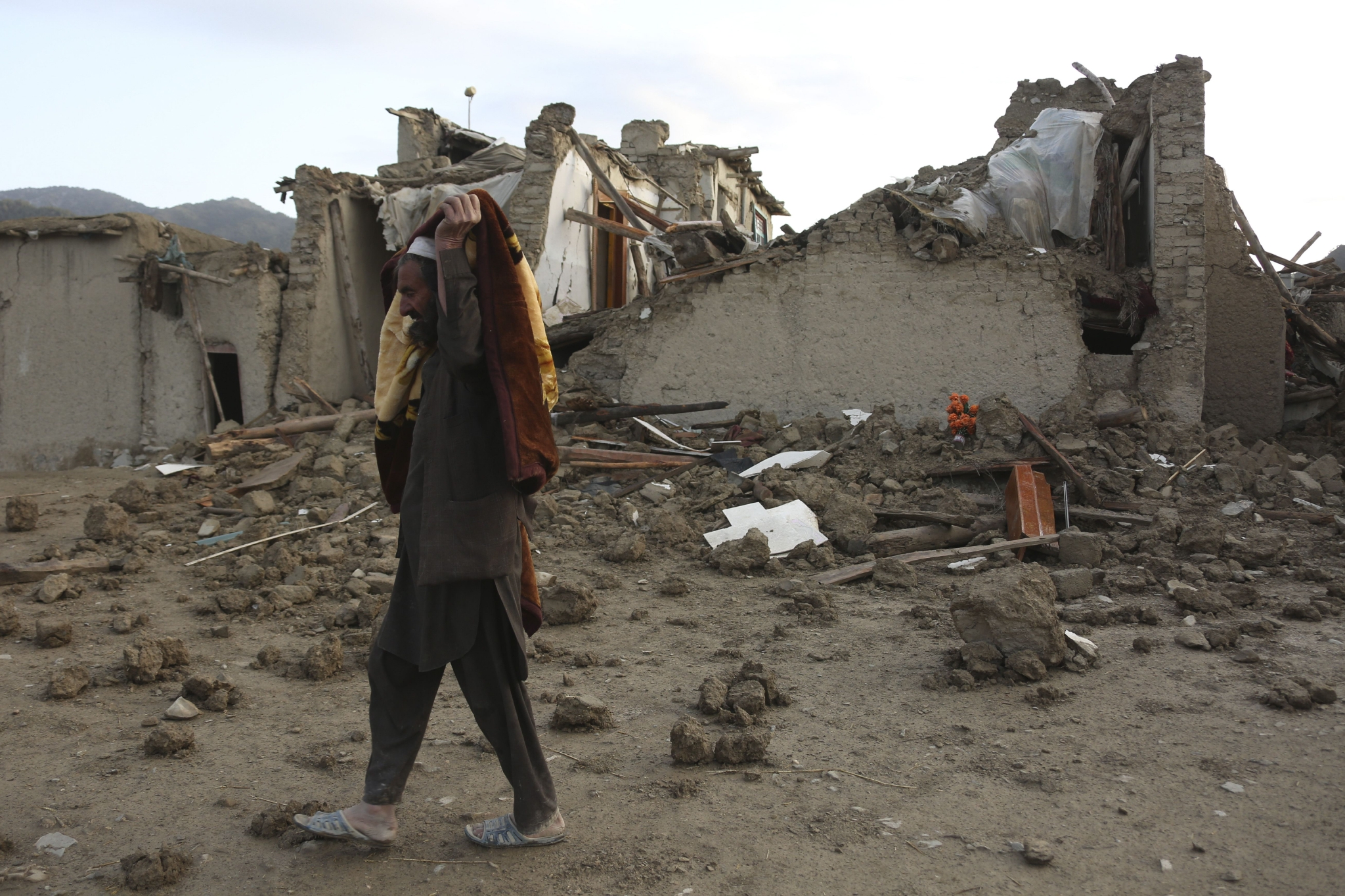 这是6月23日在阿富汗帕克提卡省拍摄的地震灾区的房屋废墟和居民衣物.